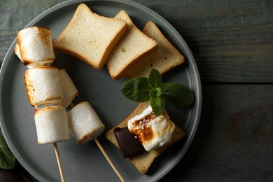 Photo of Delicious sandwich with roasted marshmallows and chocolate on grey wooden table, flat lay