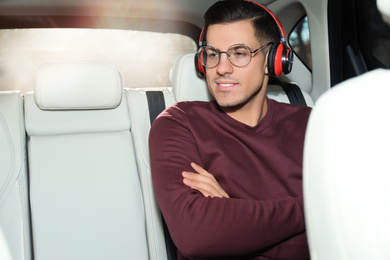 Photo of Handsome man listening to audiobook in car