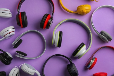 Photo of Many different headphones on color background, top view