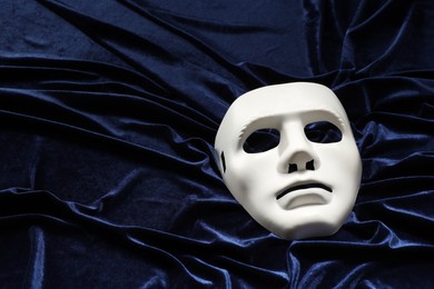 Theater arts. White mask on blue fabric, above view. Space for text