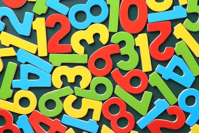 Colorful numbers on green background, top view