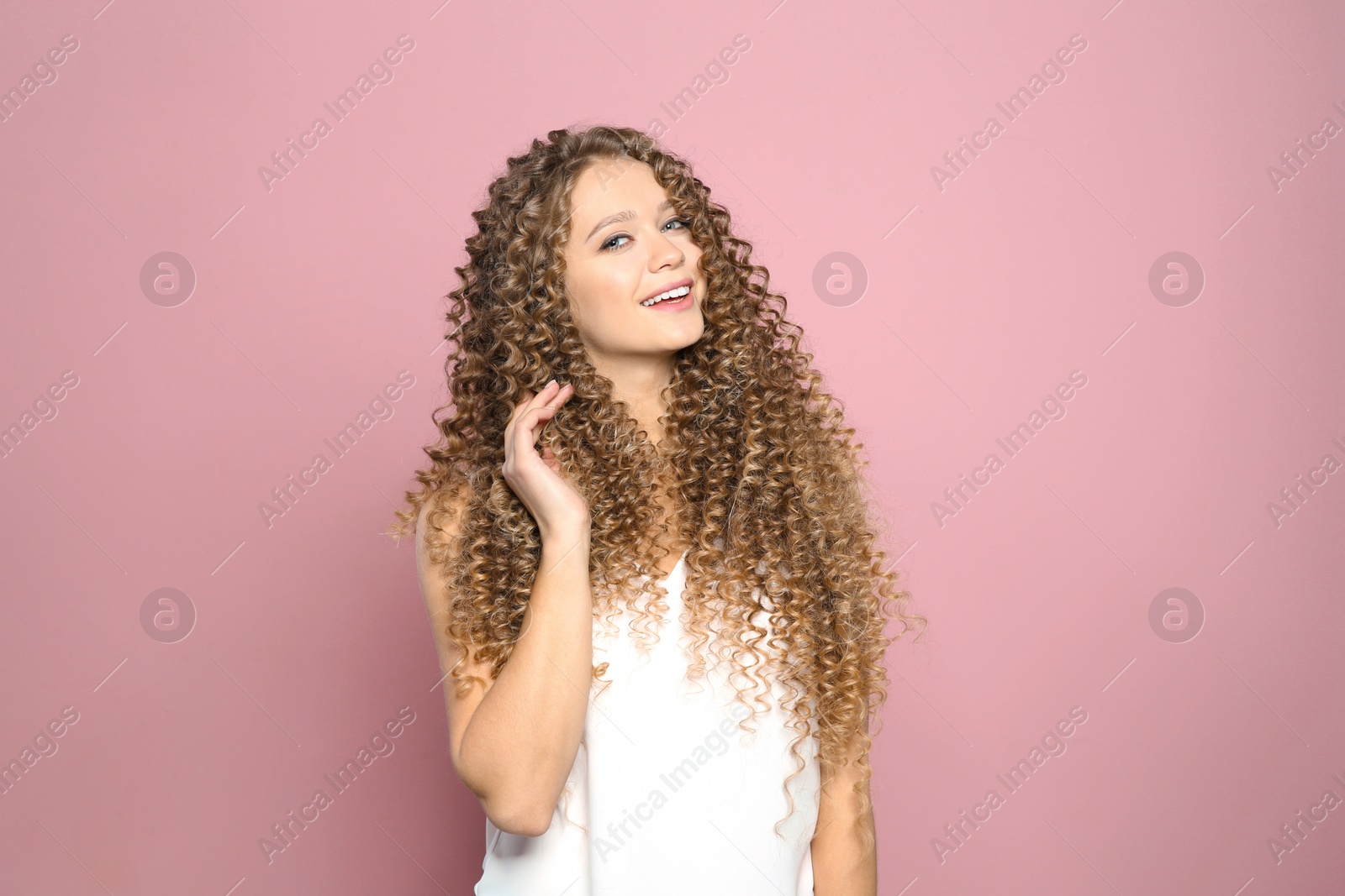 Photo of Portrait of beautiful young woman with shiny wavy hair on color background