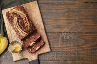 Delicious banana bread and honey on wooden table, top view. Space for text