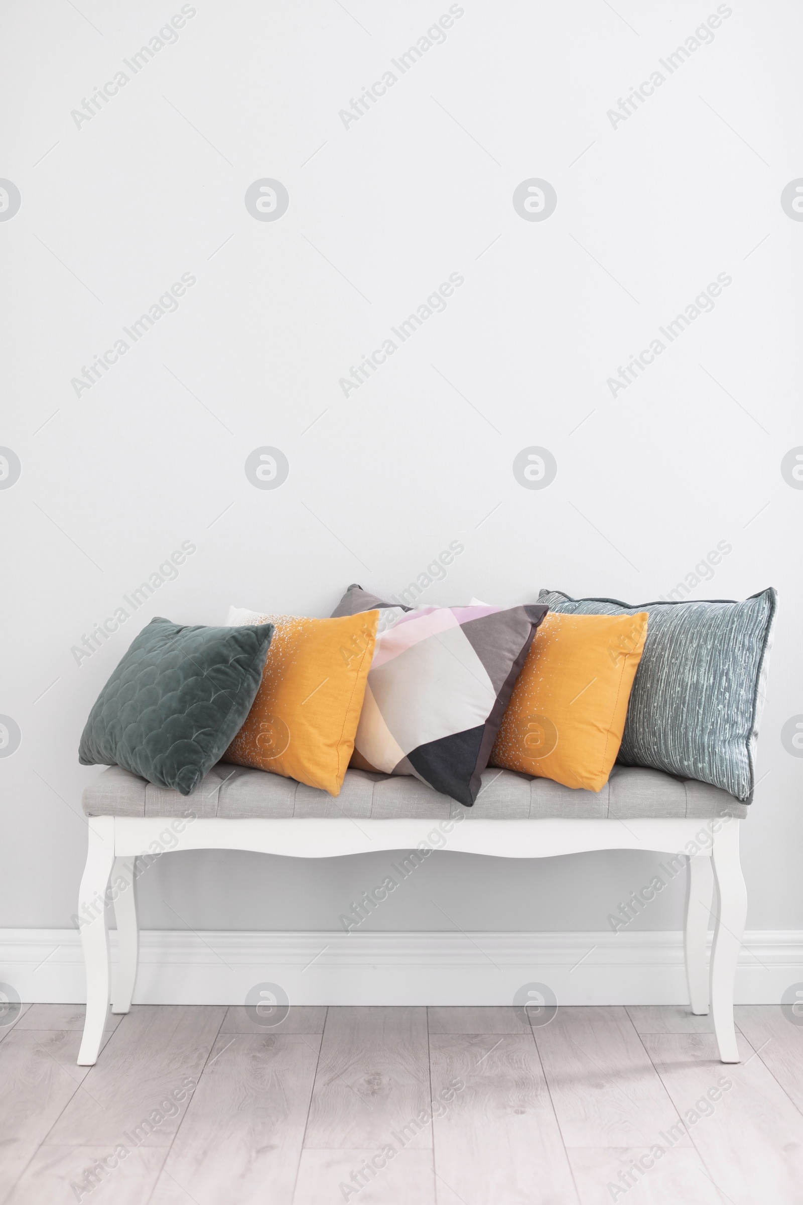 Photo of Different pillows on couch near light wall in room