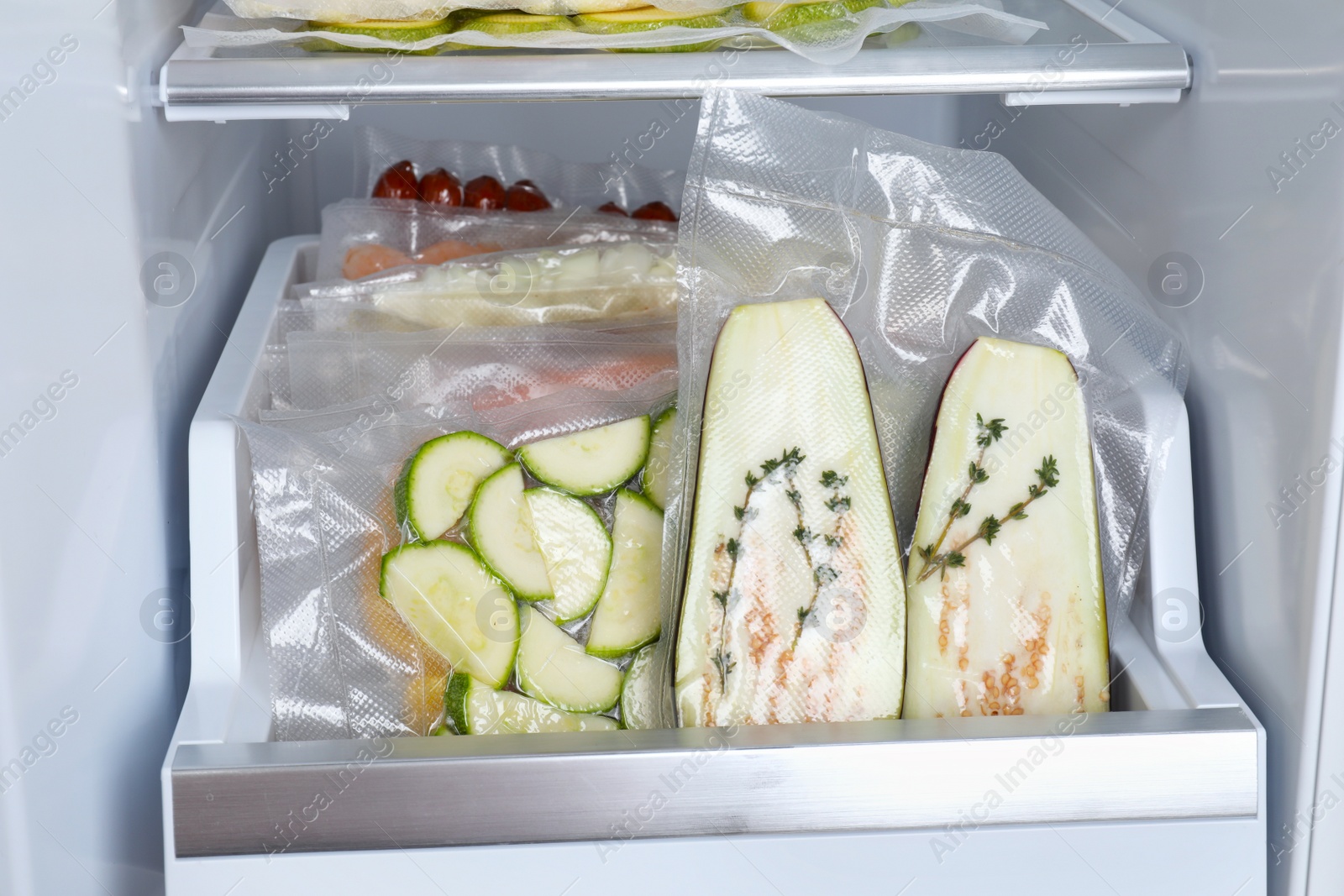 Photo of Vacuum bags with different products in fridge. Food storage