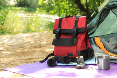 Photo of Camping equipment and modern tent in wilderness. Space for text