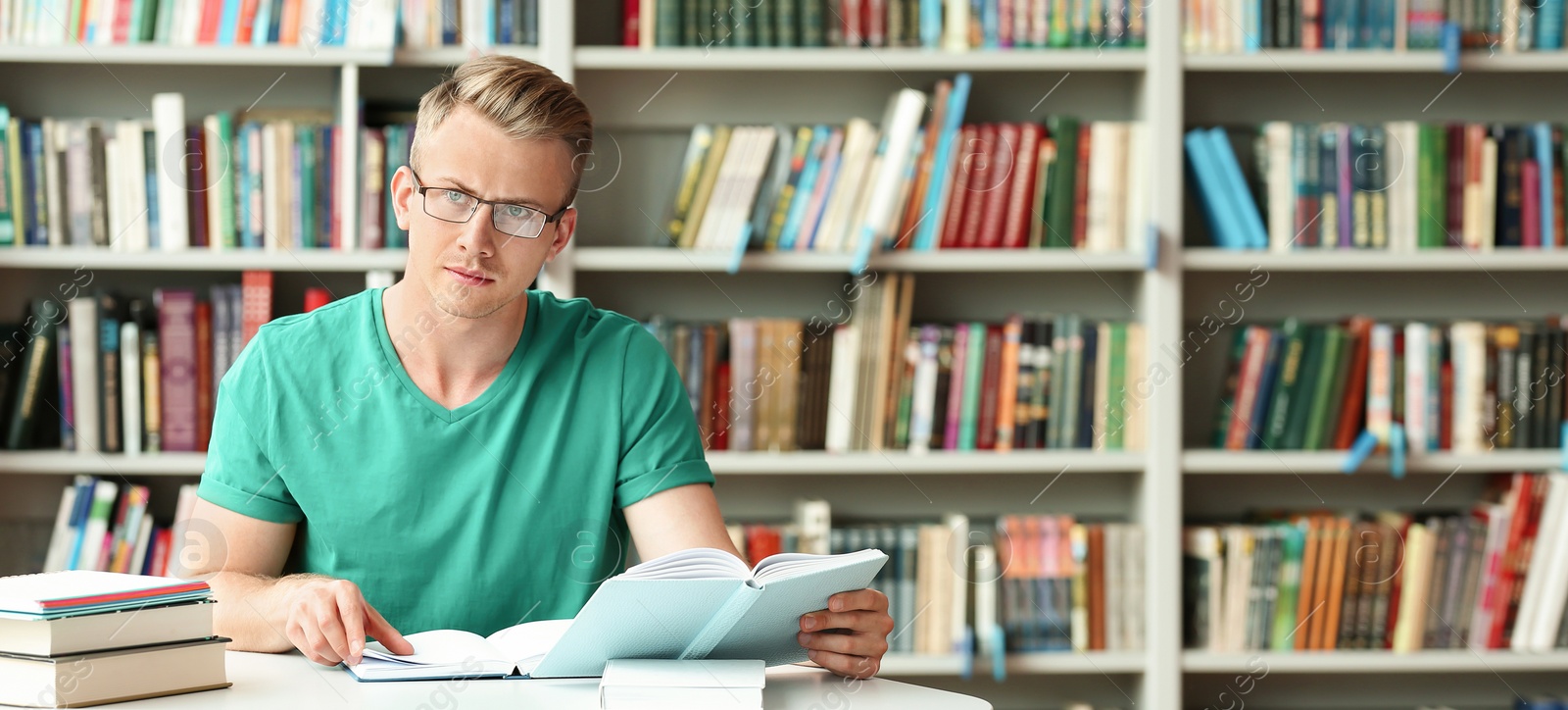 Image of Pensive young student with books at table in library, space for text. Banner design