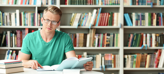 Image of Pensive young student with books at table in library, space for text. Banner design