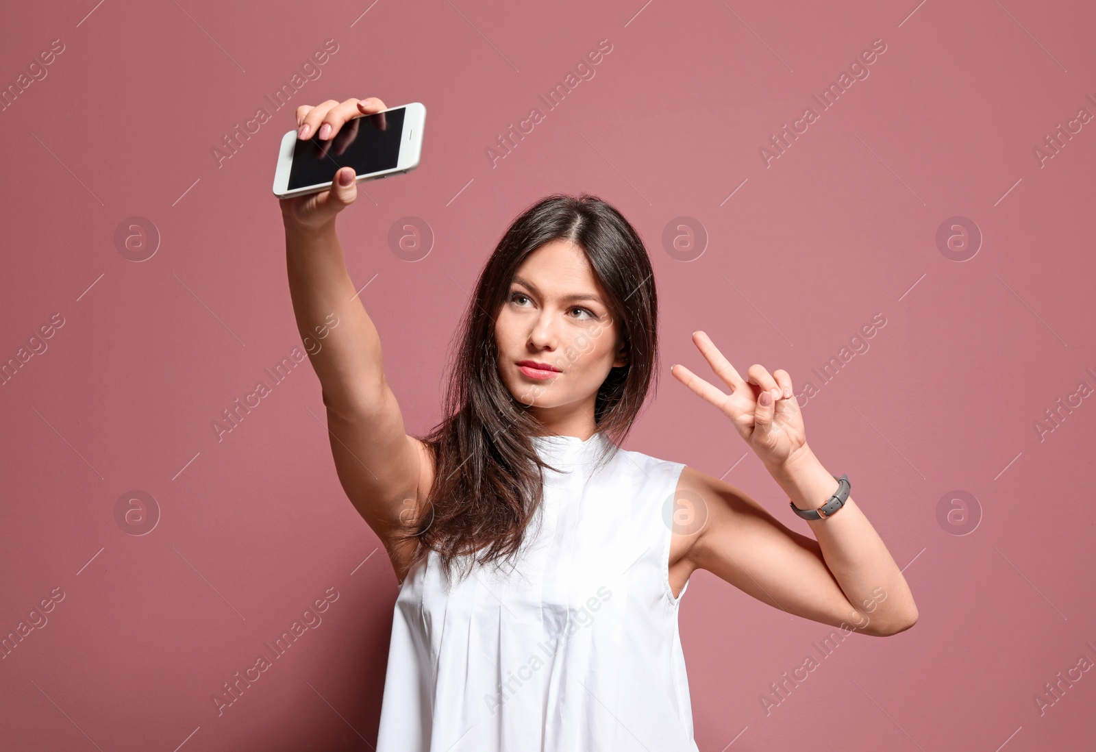 Photo of Attractive young woman taking selfie on color background