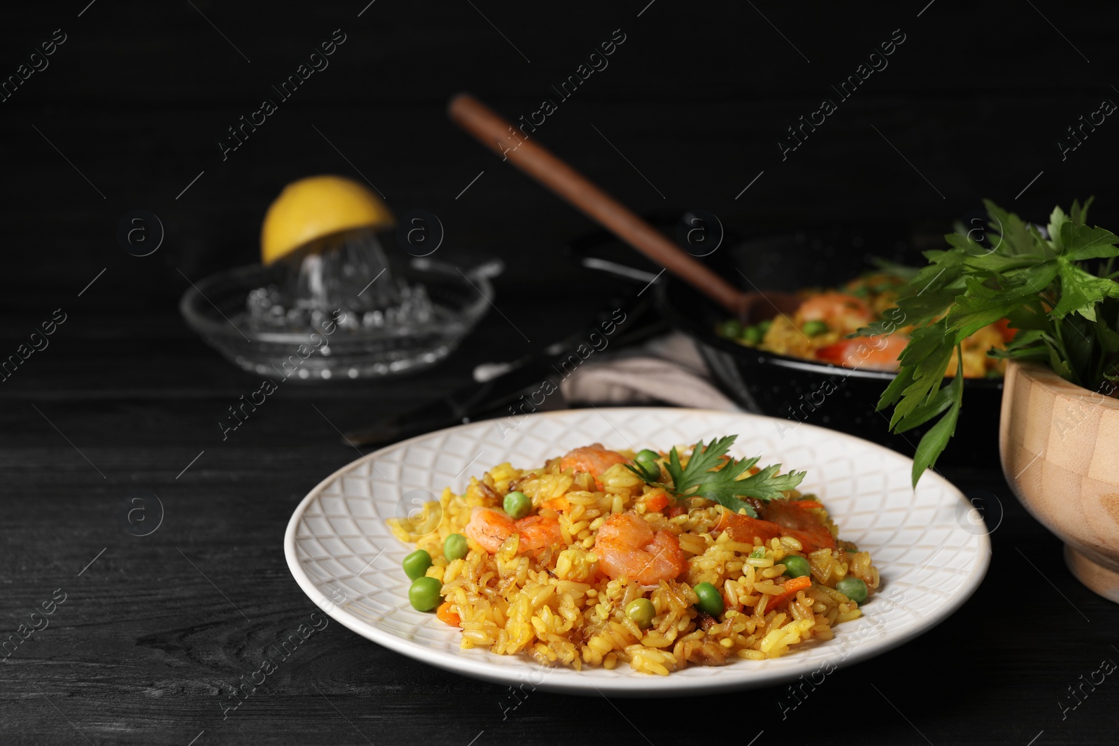 Photo of Tasty rice with shrimps and vegetables on dark wooden table. Space for text