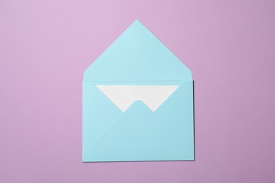 Photo of Letter envelope with card on violet background, top view