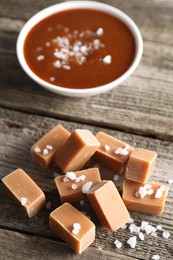 Photo of Yummy caramel candies with sea salt on wooden table, closeup