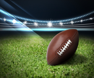 Image of Leather American ball on green football field 