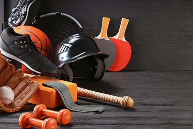 Photo of Many different sports equipment on dark grey wooden table, space for text