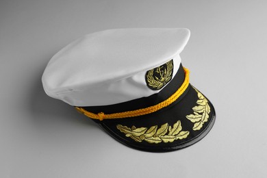 Photo of Peaked cap with accessories on light grey background