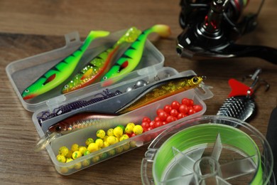 Photo of Different fishing baits on wooden background, closeup