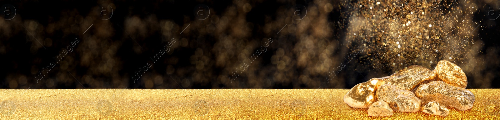 Image of Gold dust falling on gold nuggets against dark background. Banner design with space for text