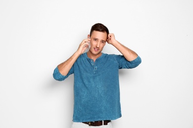 Young man talking on phone against white background