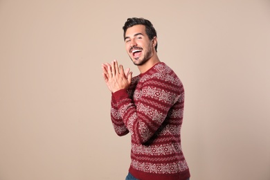 Photo of Portrait of happy man in Christmas sweater on beige background