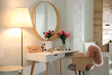 Stylish room interior with dressing table and mirror