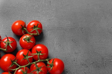 Fresh cherry tomatoes on stone background, flat lay. Space for text