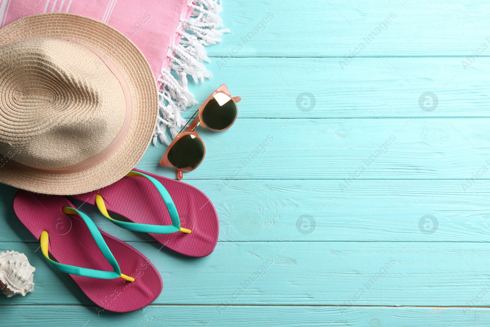 Photo of Beach accessories on light blue wooden table, flat lay. Space for text