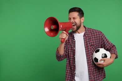 Emotional sports fan with ball and megaphone on green background. Space for text