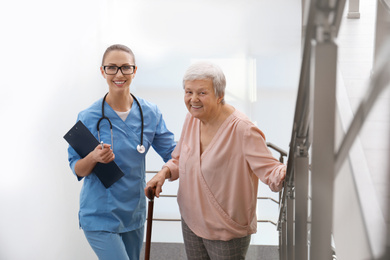 Photo of Doctor helping senior patient in modern hospital