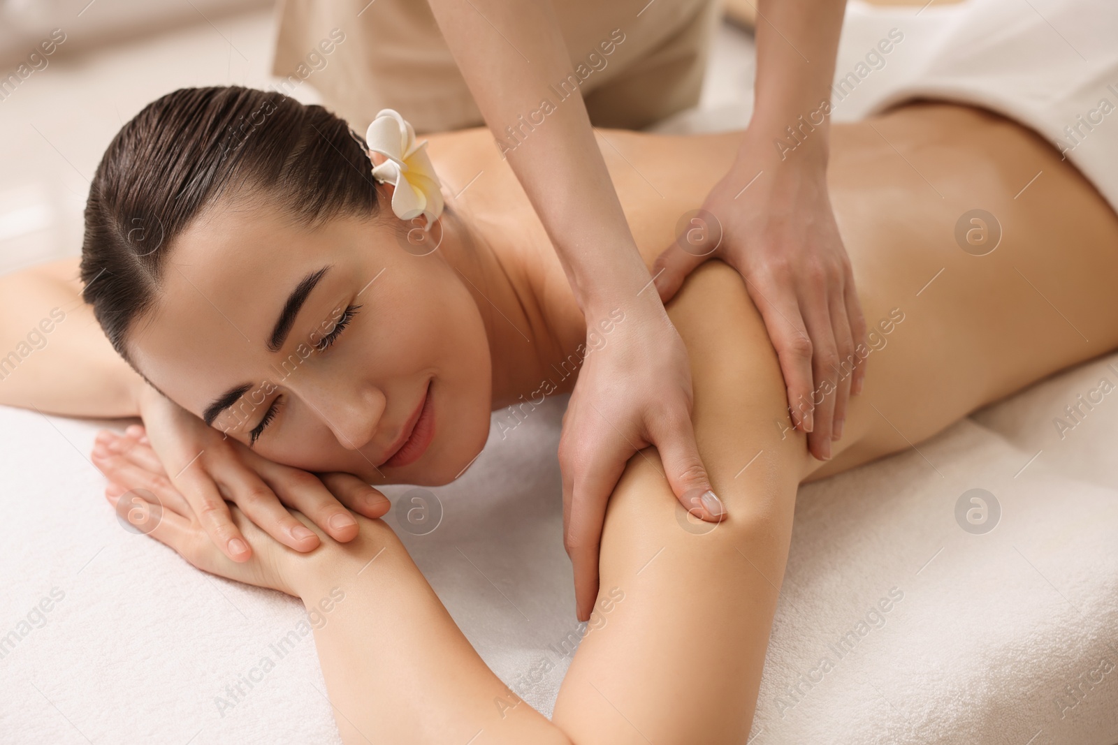 Photo of Woman receiving massage on couch in spa salon