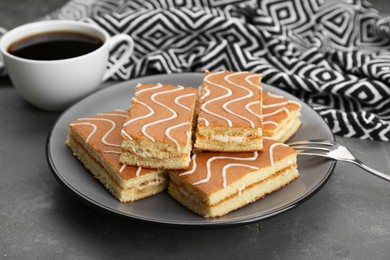 Photo of Tasty sponge cakes and hot drink on grey table