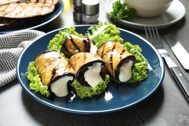 Photo of Plate with fried eggplant rolls on table