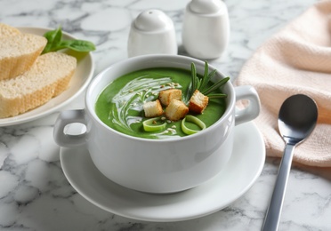 Fresh vegetable detox soup with croutons served on table