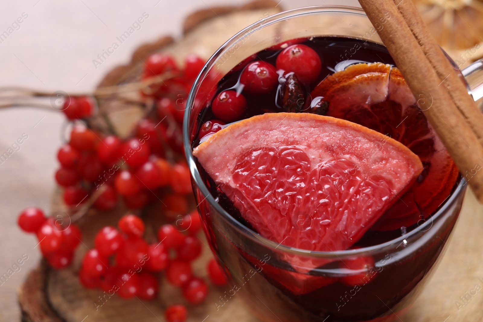 Photo of Aromatic mulled wine in glass cup on table, closeup. Space for text