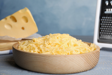 Tasty grated cheese on light grey wooden table