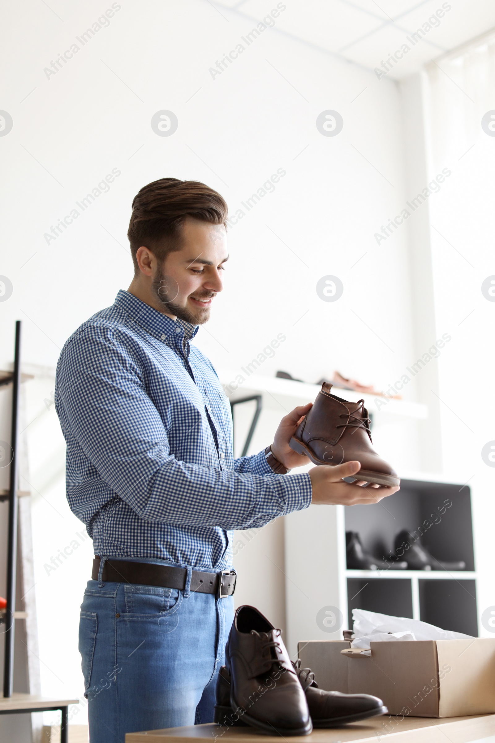 Photo of Young man choosing shoes in store