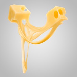 Image of Tasty cheese stretching in air on grey background