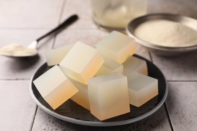 Photo of Agar-agar jelly cubes on tiled surface, closeup