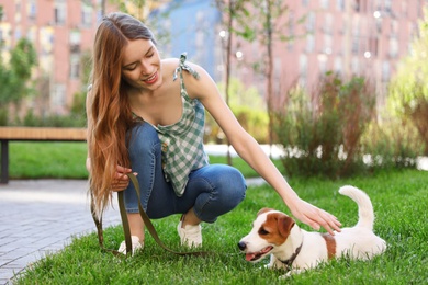 Photo of Young woman with adorable Jack Russell Terrier dog outdoors