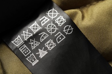 Photo of Clothing label on beautiful garment, closeup view