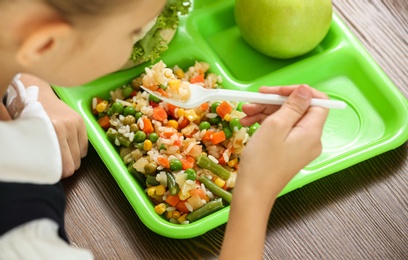 Photo of Child with healthy food for school lunch at desk, closeup