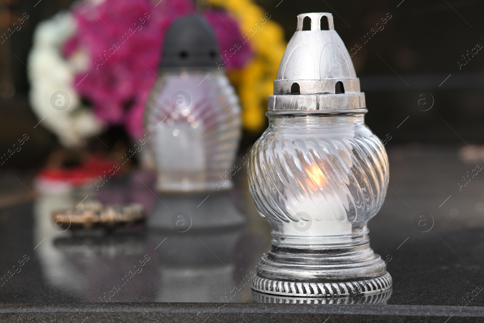 Photo of Grave lanterns on granite surface in cemetery, space for text