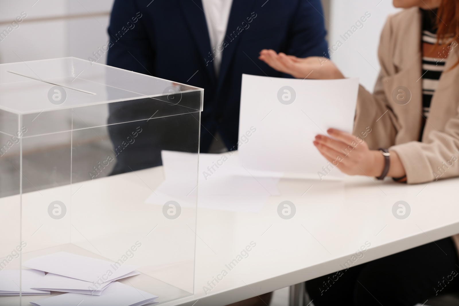 Photo of Polling station workers at table with ballot box