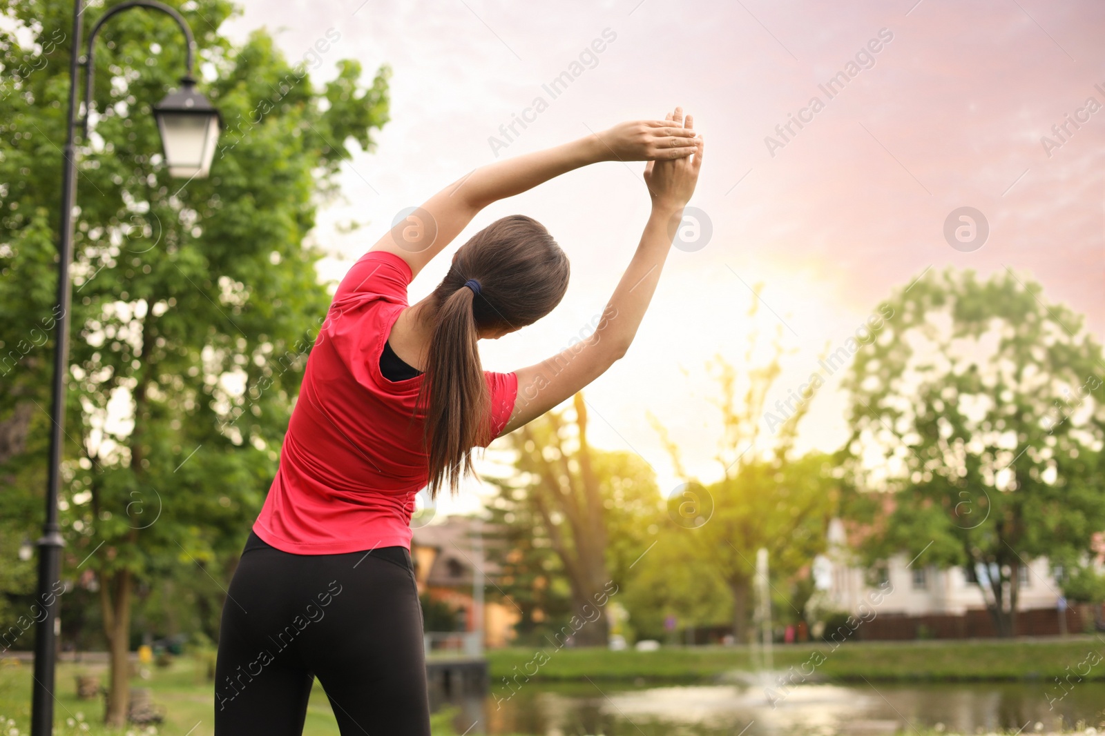 Photo of Woman doing morning exercise in park, back view. Space for text