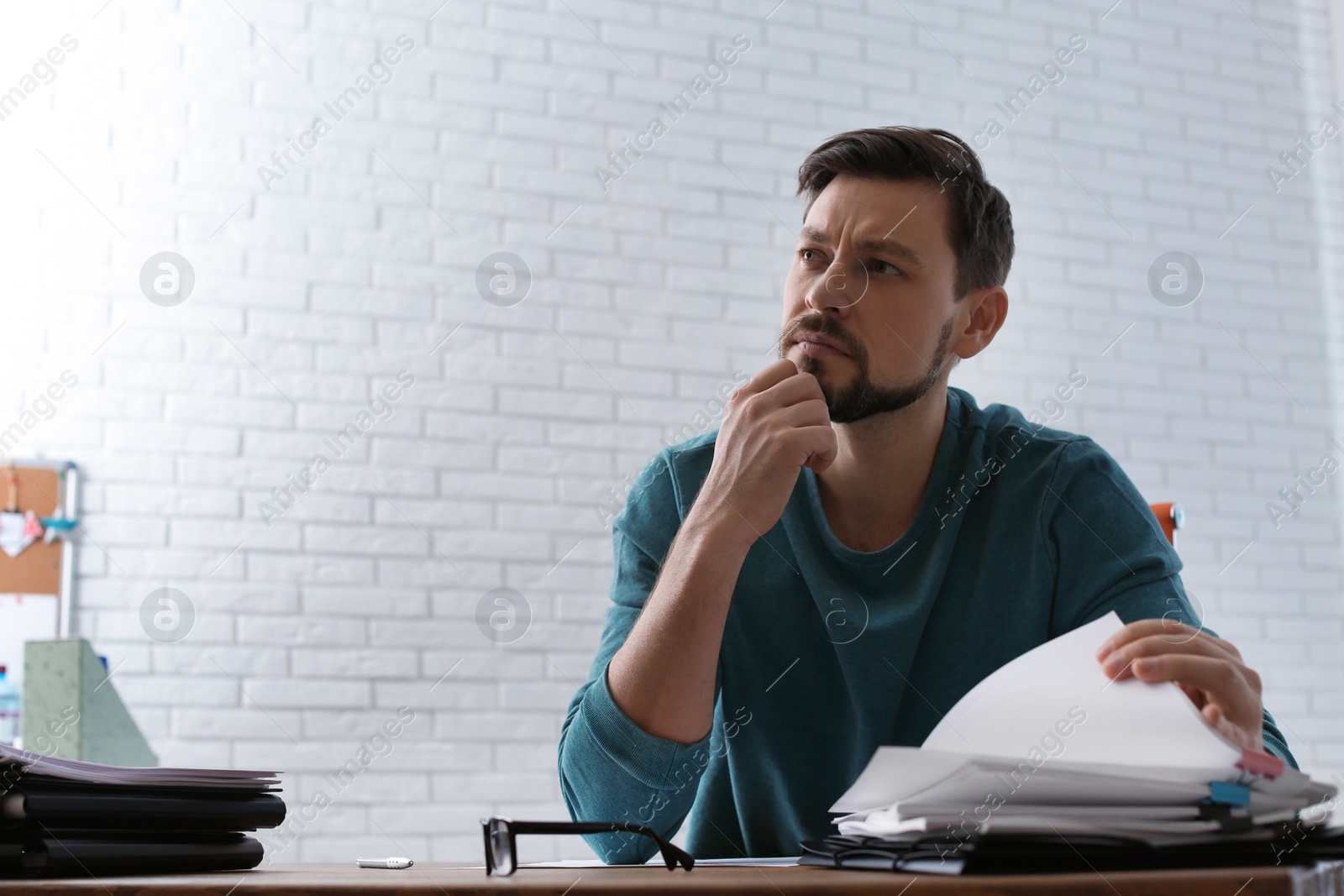 Photo of Man working with documents at table in office. Space for text