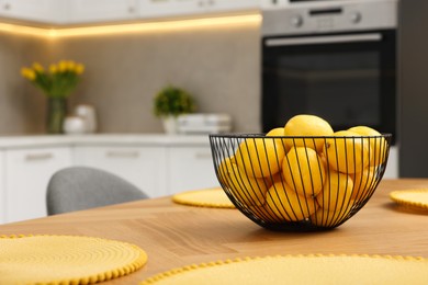 Photo of Spring interior. Bowl of lemons on wooden table in kitchen, space for text