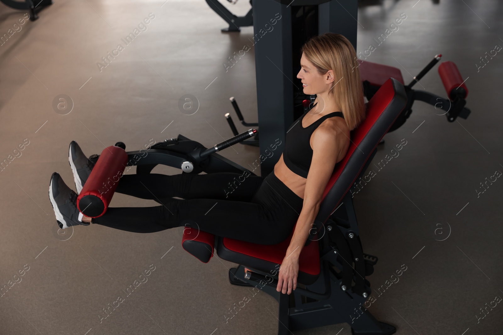 Photo of Woman training with leg extension machine in gym