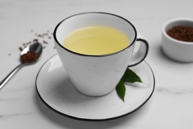 Cup of buckwheat tea on white marble table, closeup