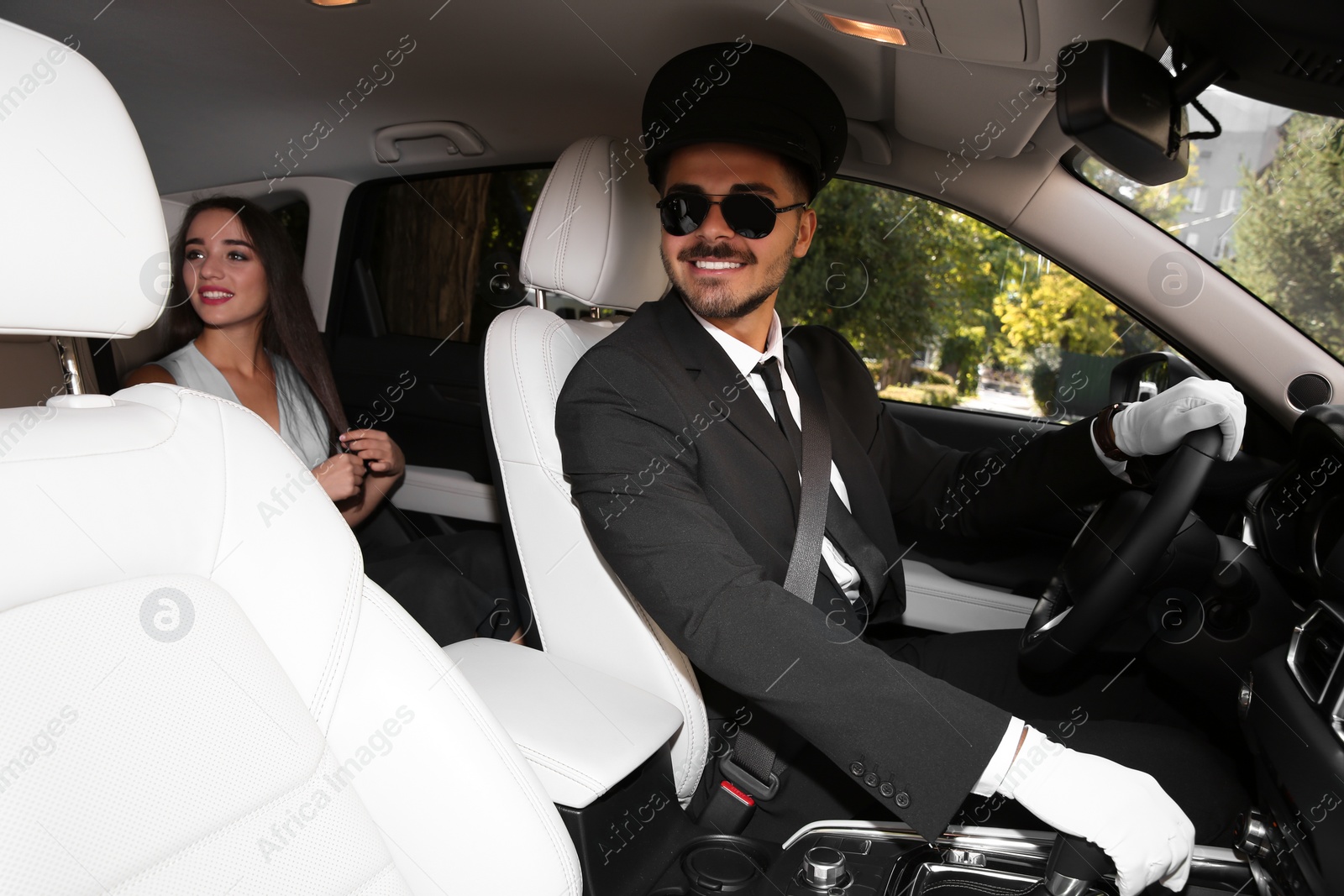 Photo of Young businesswoman with handsome driver in luxury car