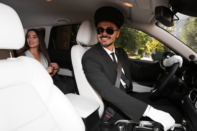 Photo of Young businesswoman with handsome driver in luxury car