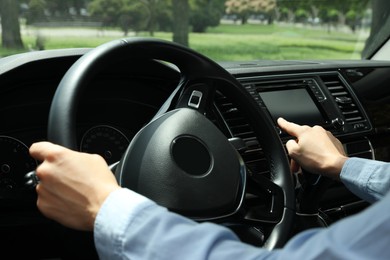 Photo of Woman using navigation system while driving car, closeup
